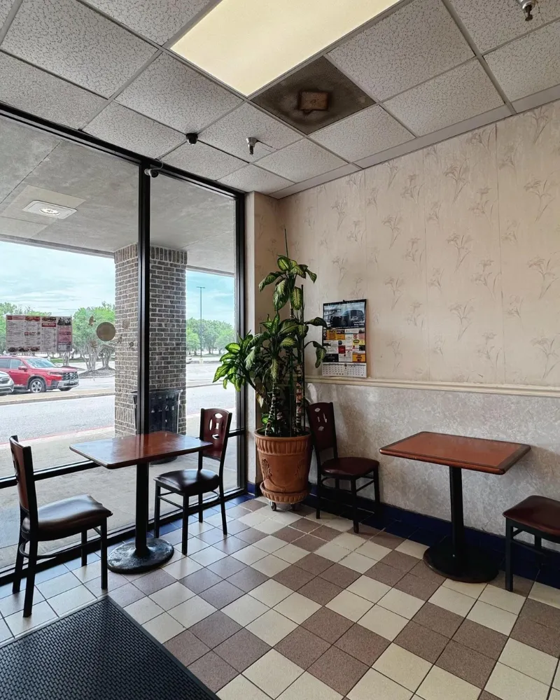 Indoor dine-in seating area with tables and green plants at China Chef Restaurant, a Chinese Restaurant in Daphne